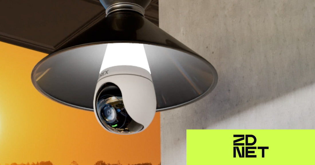 Lorex 2K lightbulb security camera mounted inside a black outdoor fixture at sunset. ZDNet logo appears in the bottom right corner.