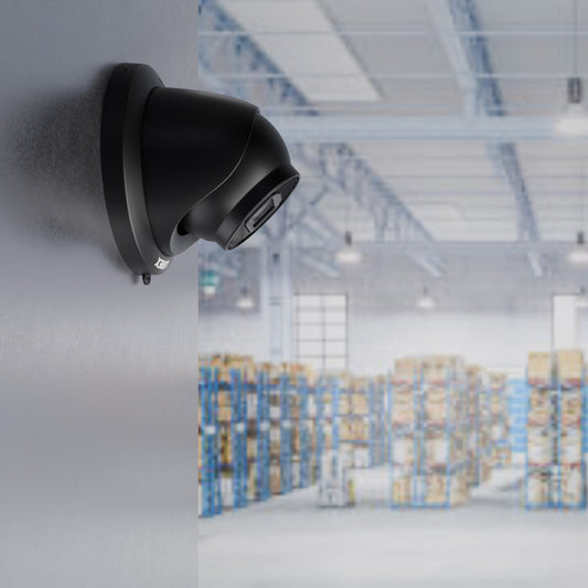 Black Lorex 4MP (2K) A4 IP turret security camera mounted on a warehouse wall, overlooking a large storage area with shelves and boxes—ideal for restaurant supply rooms or food service inventory monitoring.