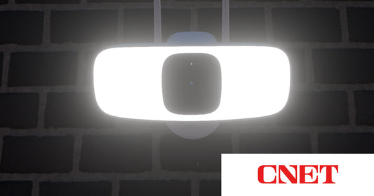 Lorex Connect 2K Floodlight Camera illuminated at night, featured by CNET as the best overall security camera with lights.
