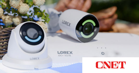 Lorex security cameras and 4K NVR on an outdoor picnic table with bread, flowers, and a spring setting in the background